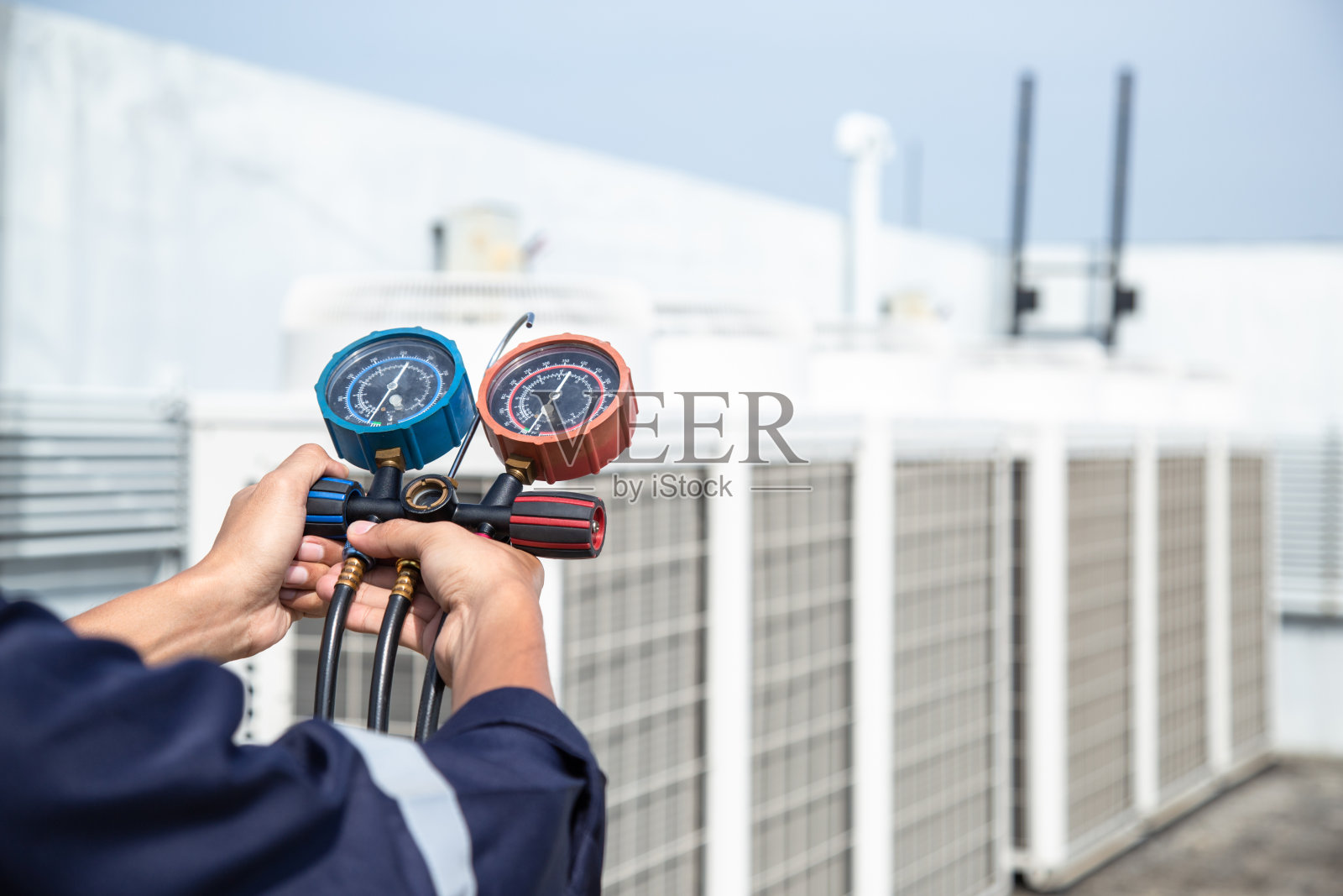 技术员正在检查空调机，测量空调机灌装设备。照片摄影图片