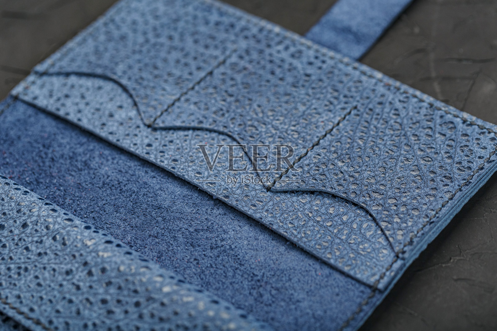 纹理蓝色皮革在黑色背景上的特写。照片摄影图片