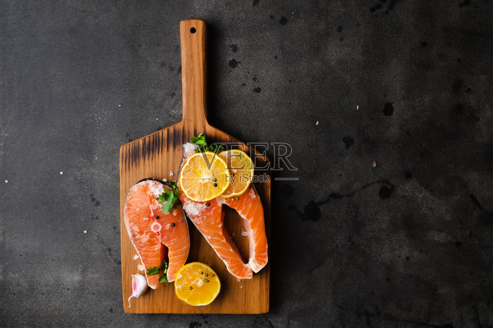 木砧板上放着新鲜的生鲑鱼和红辣椒照片摄影图片