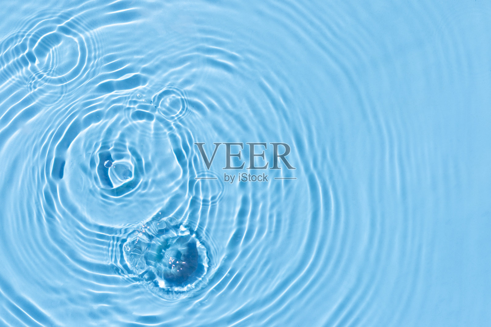 阳光下蓝色水面上的水滴和灯泡。俯视图，平躺照片摄影图片