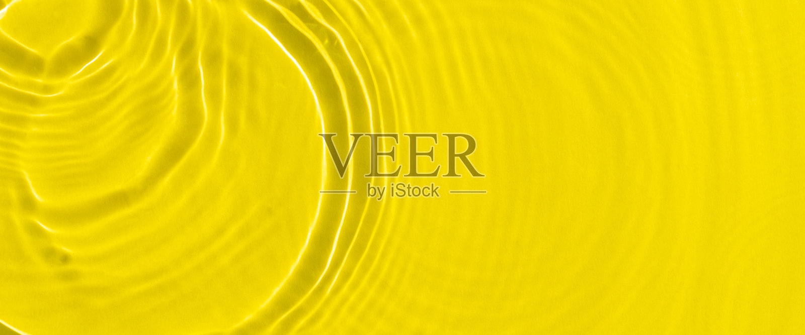 阳光下，水滴落在黄色的水面上。俯视图，平躺。横幅照片摄影图片