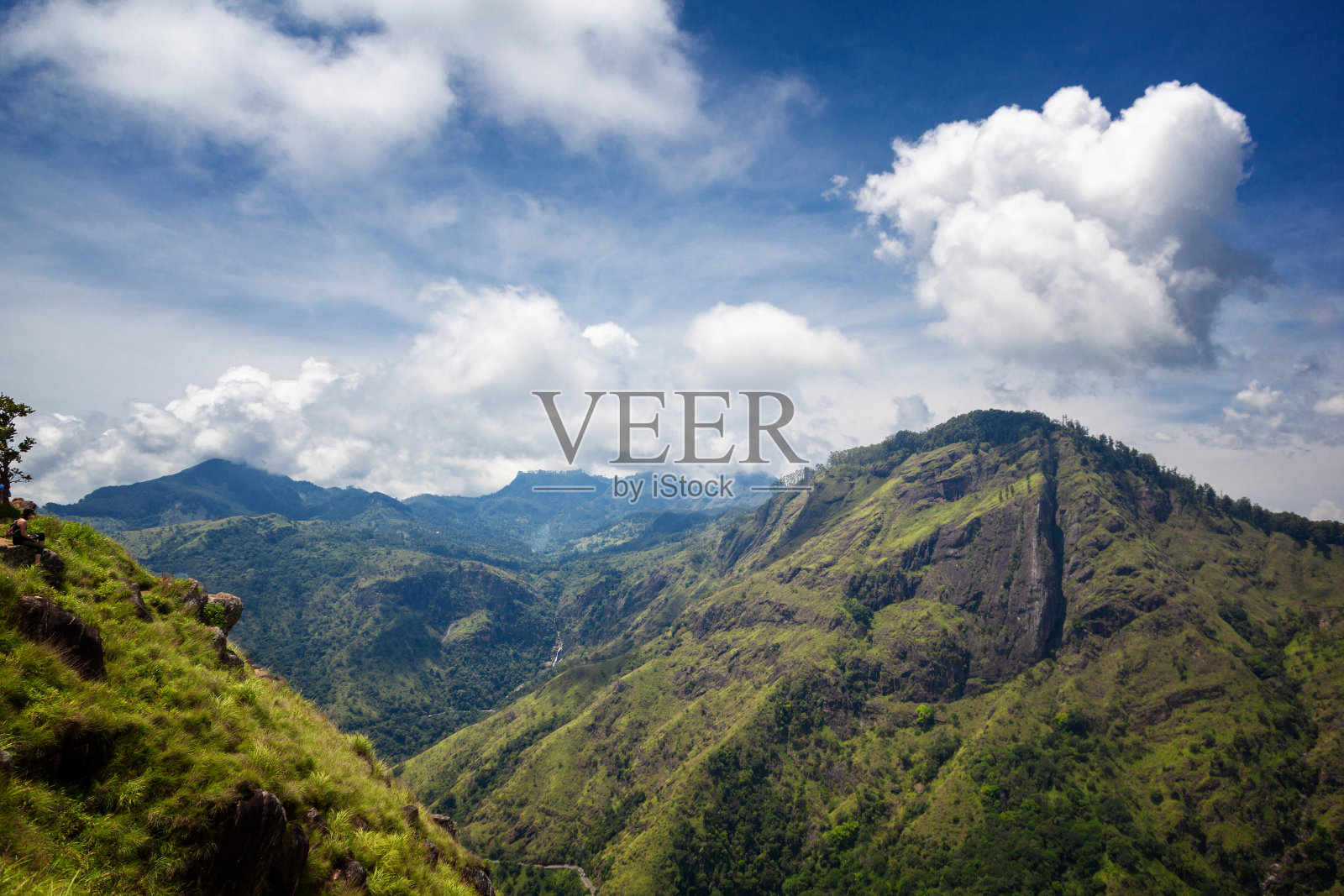 绿色的山，蓝色的天空和戏剧性的云照片摄影图片