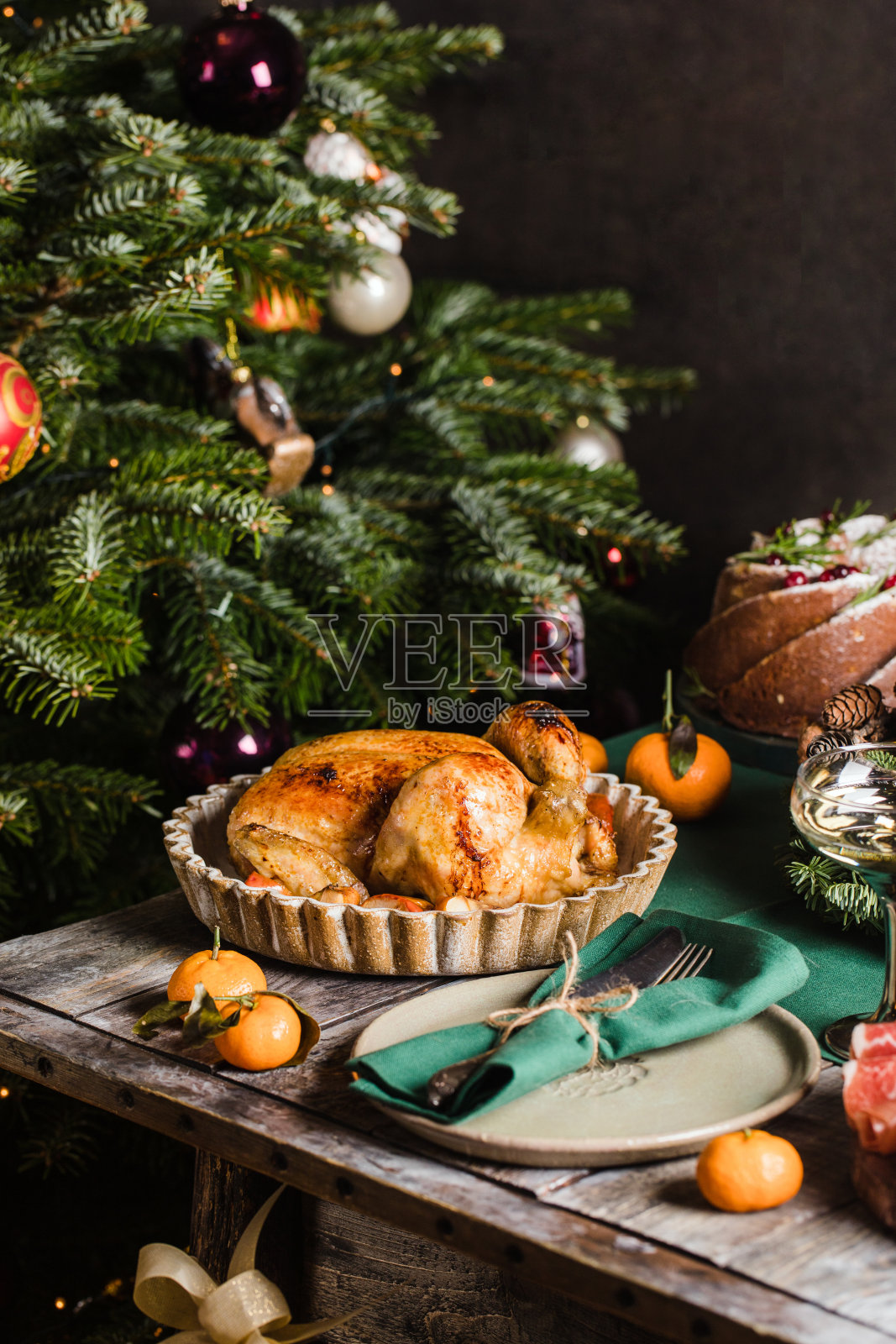 烤鸡是节日的主菜，餐桌上装饰着花环。圣诞节新年家庭庆祝概念照片摄影图片