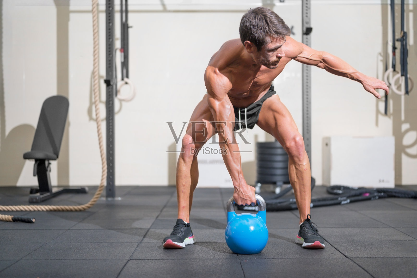 年轻的肌肉男在用壶铃训练。高质量的照片照片摄影图片
