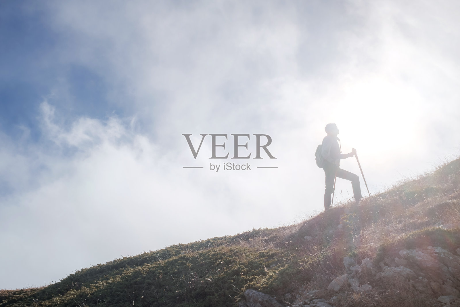 一名年轻女子背着背包登上山顶照片摄影图片