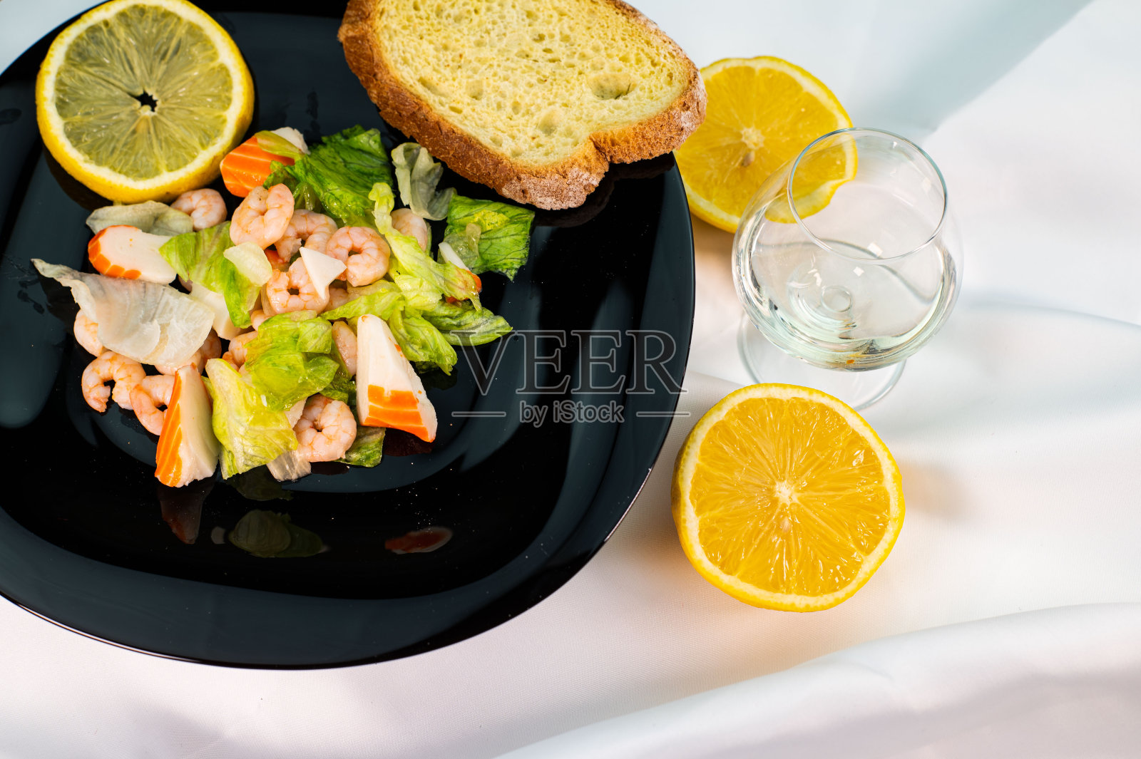 黑色的盘子里有虾和鱼糜沙拉照片摄影图片