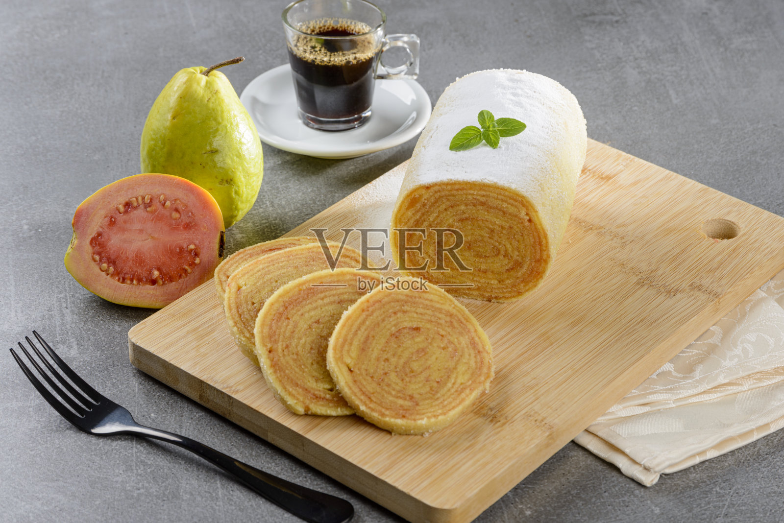木桌上的番石榴酱瑞士卷(蛋糕)。有选择性的重点。照片摄影图片