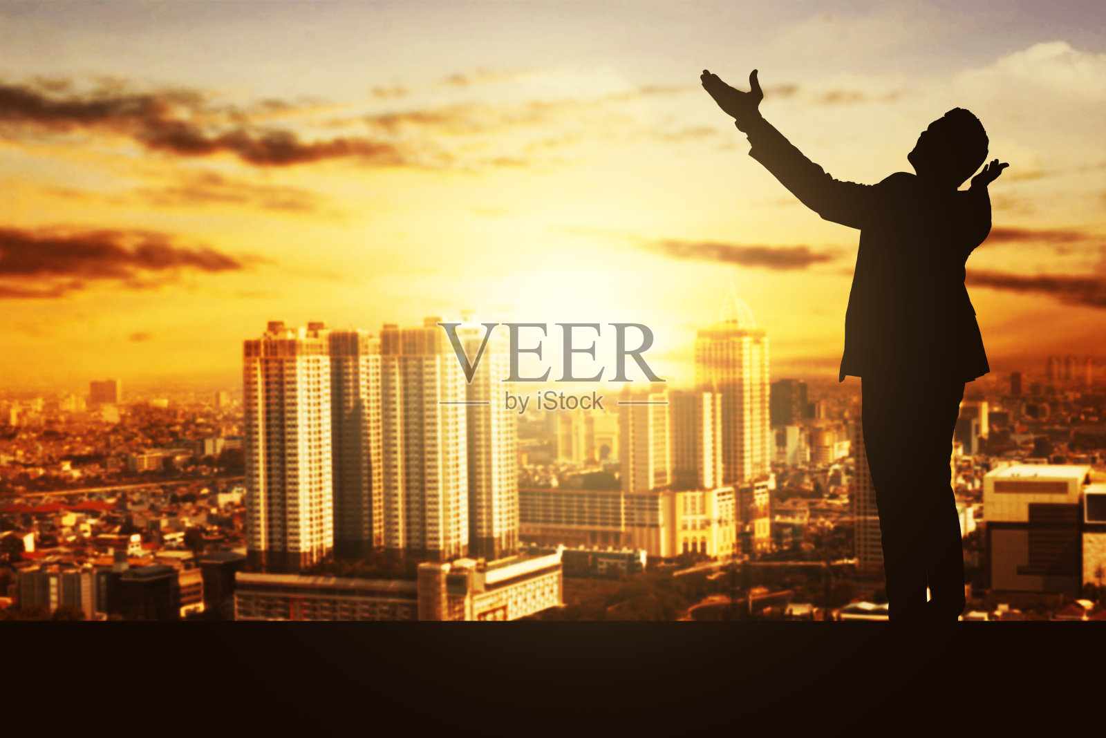 一个商人的剪影，站着举手照片摄影图片