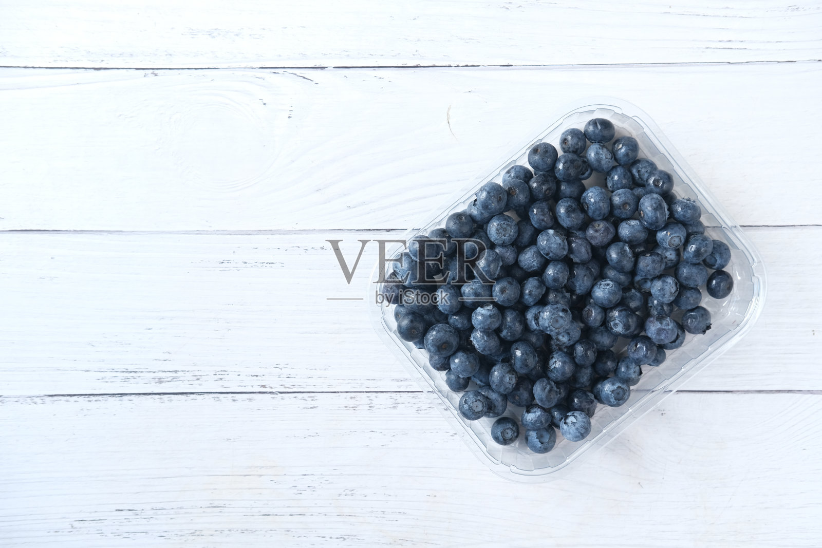 新鲜的蓝色浆果在塑料容器与复制空间照片摄影图片