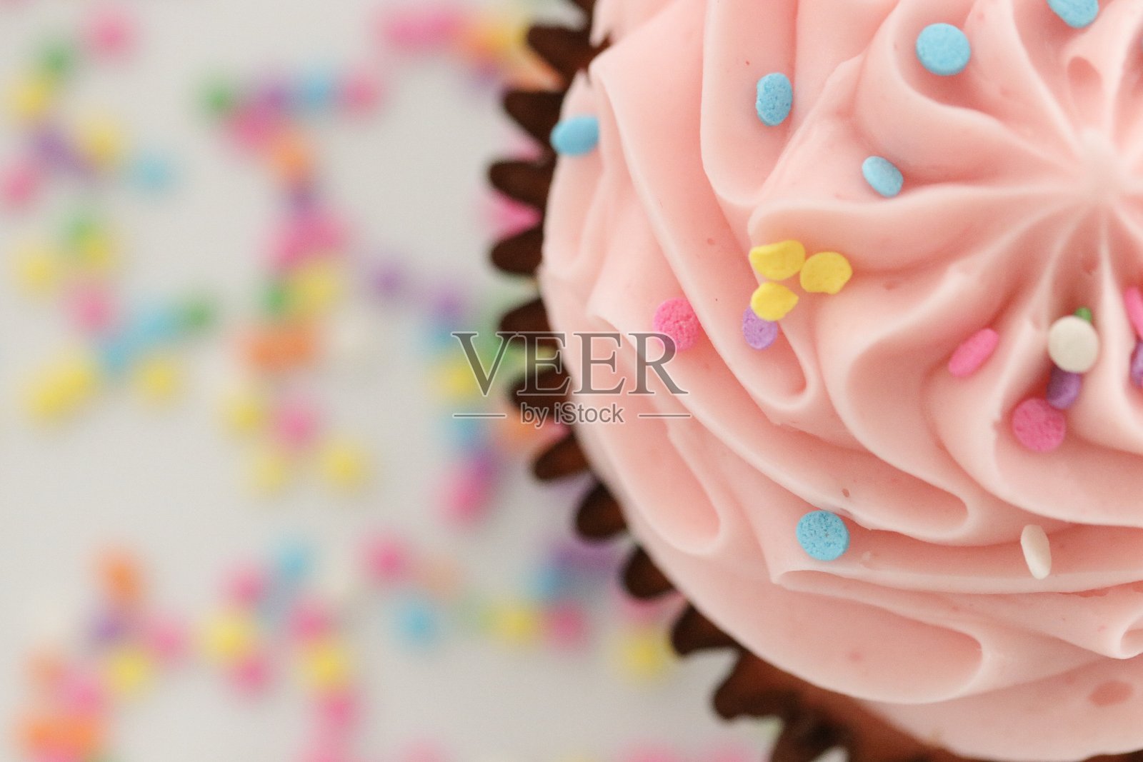 草莓蛋糕，上面有粉色的糖霜和糖屑照片摄影图片