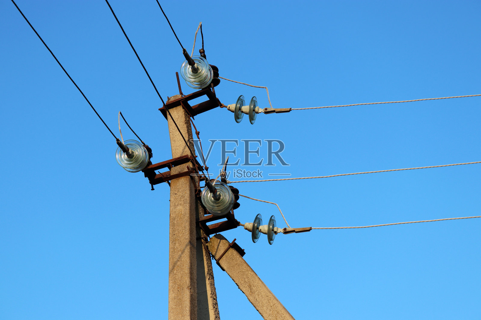 电力线柱与电线和电容器隔离在蓝天背景照片摄影图片
