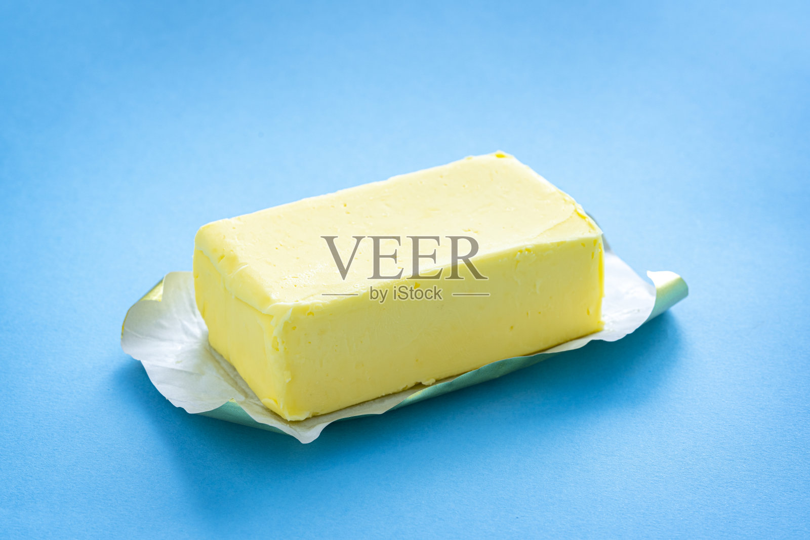 蓝色背景上的单根黄油棒照片摄影图片