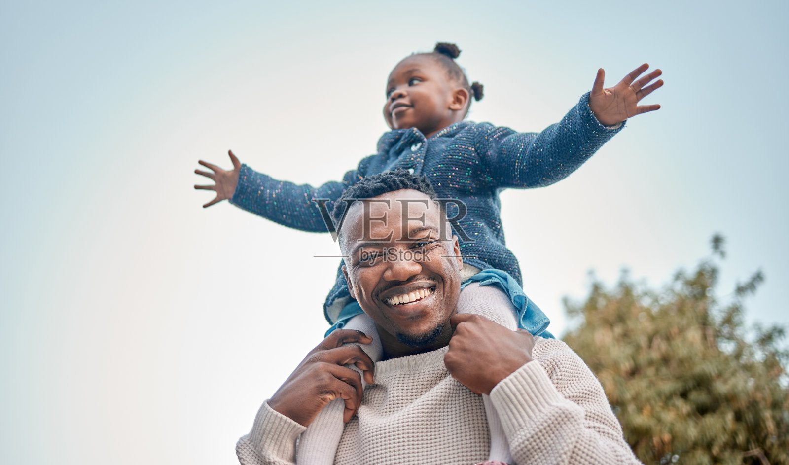 在户外，父亲把女儿扛在肩上照片摄影图片