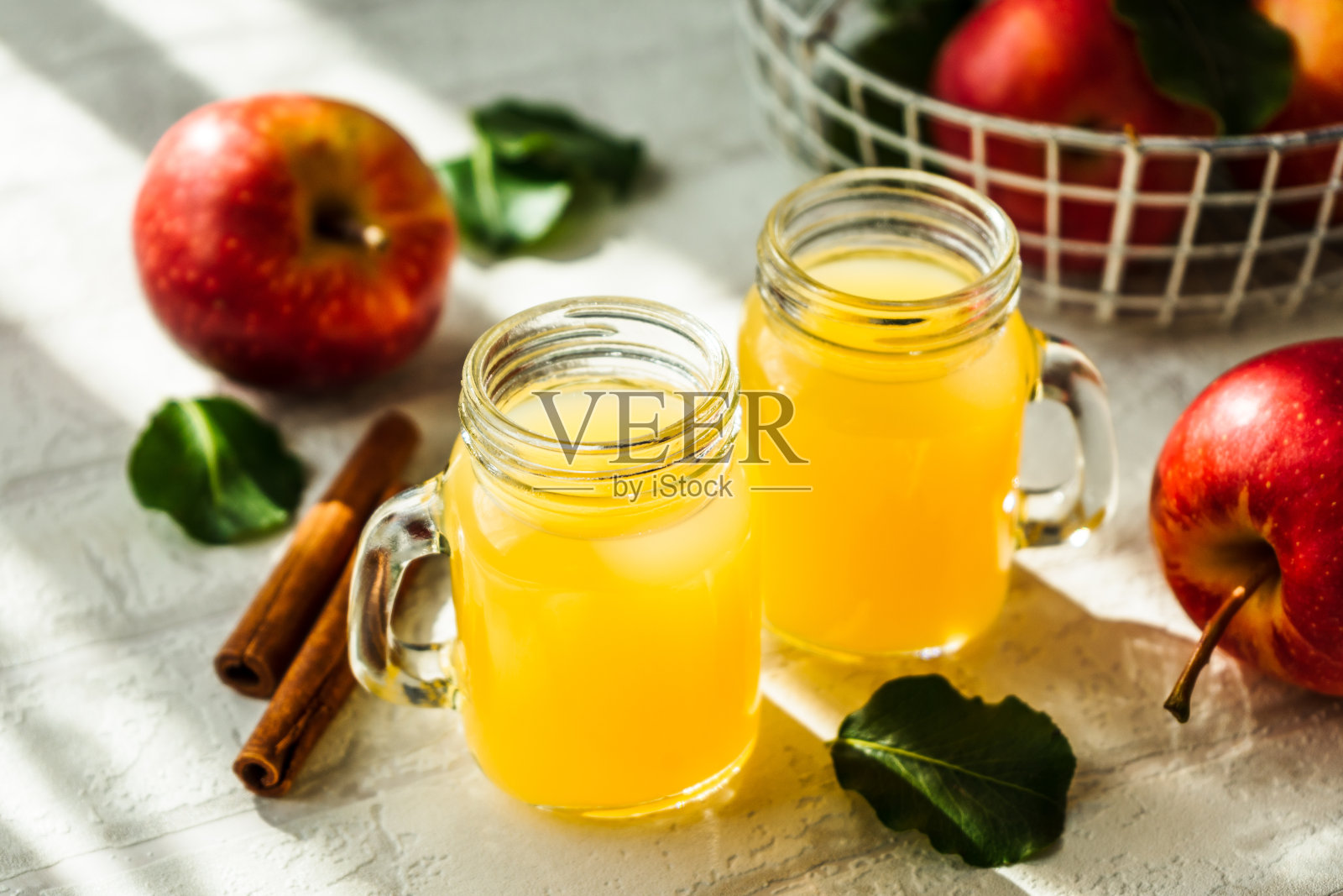 两杯新鲜苹果汁，桌上放着整只苹果照片摄影图片