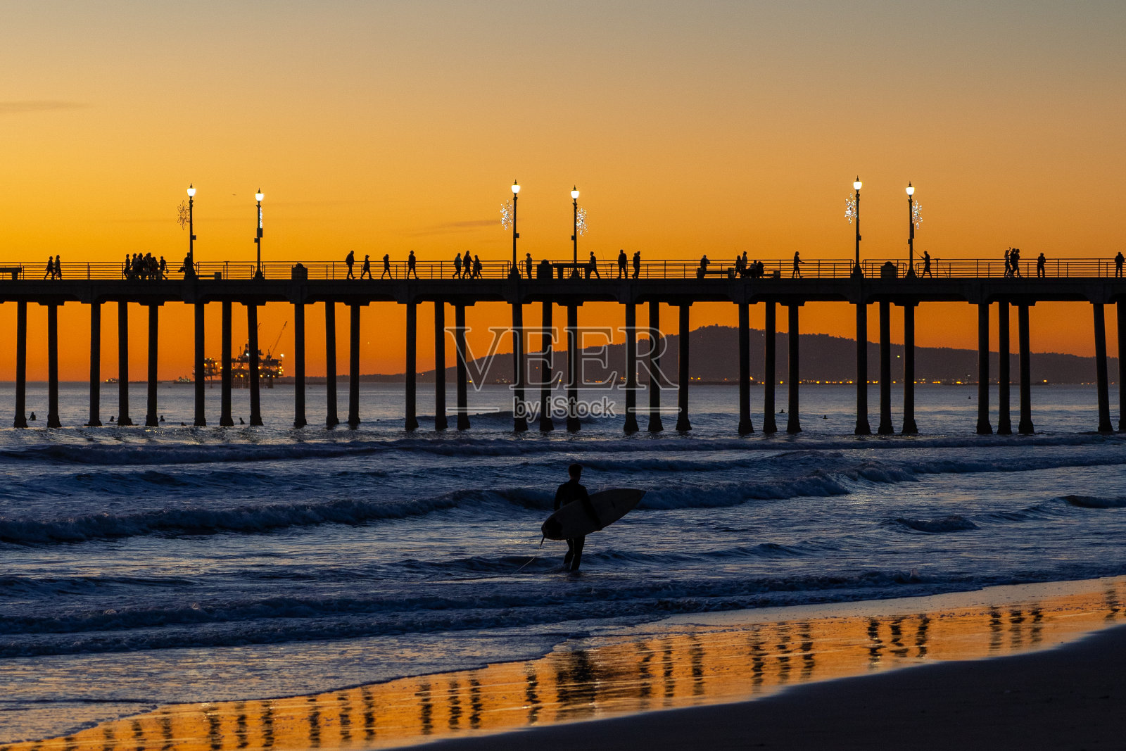 冲浪者在日落时分照片摄影图片