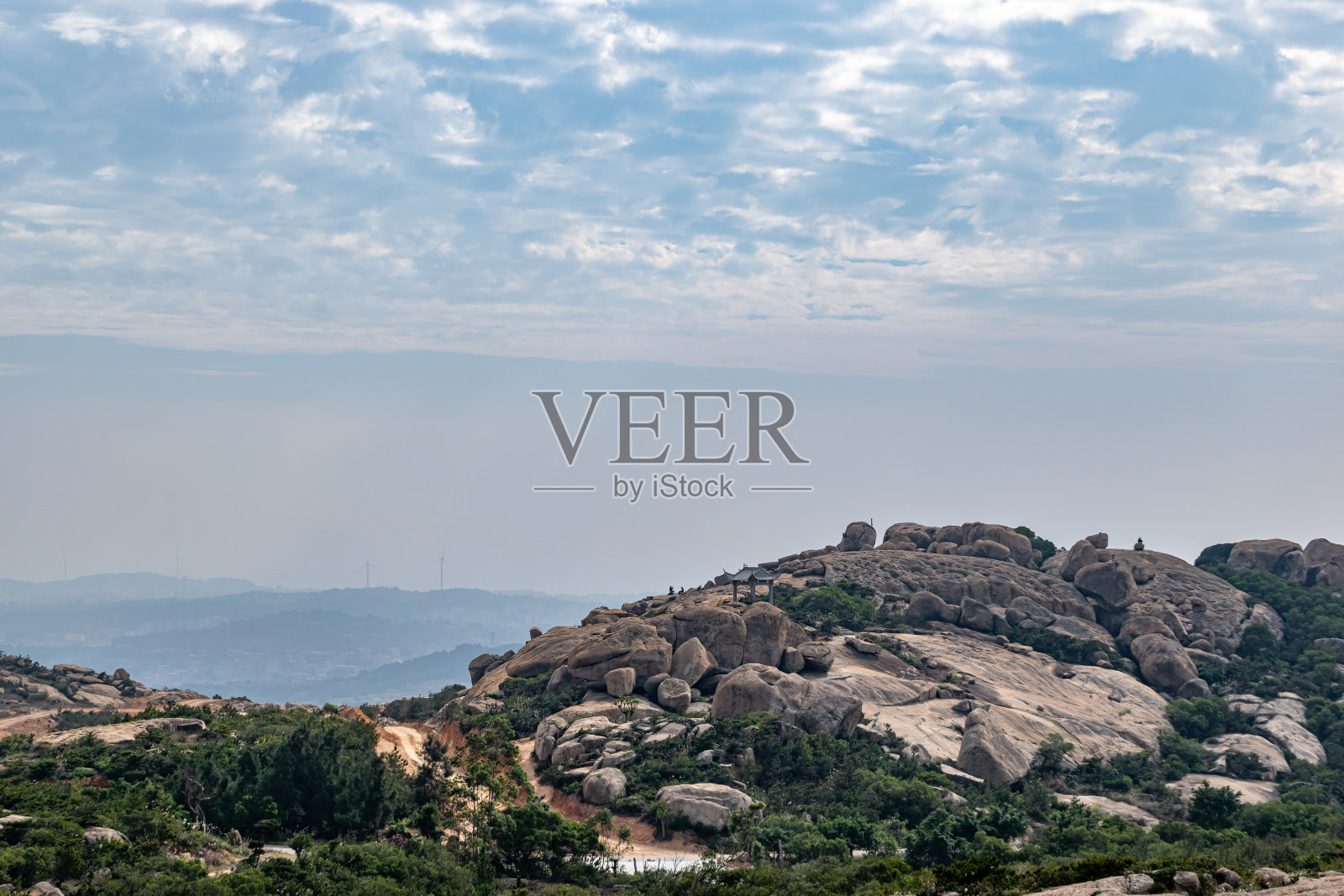 在沿海岸的山上，很少有植物和许多不同形状的大石头照片摄影图片