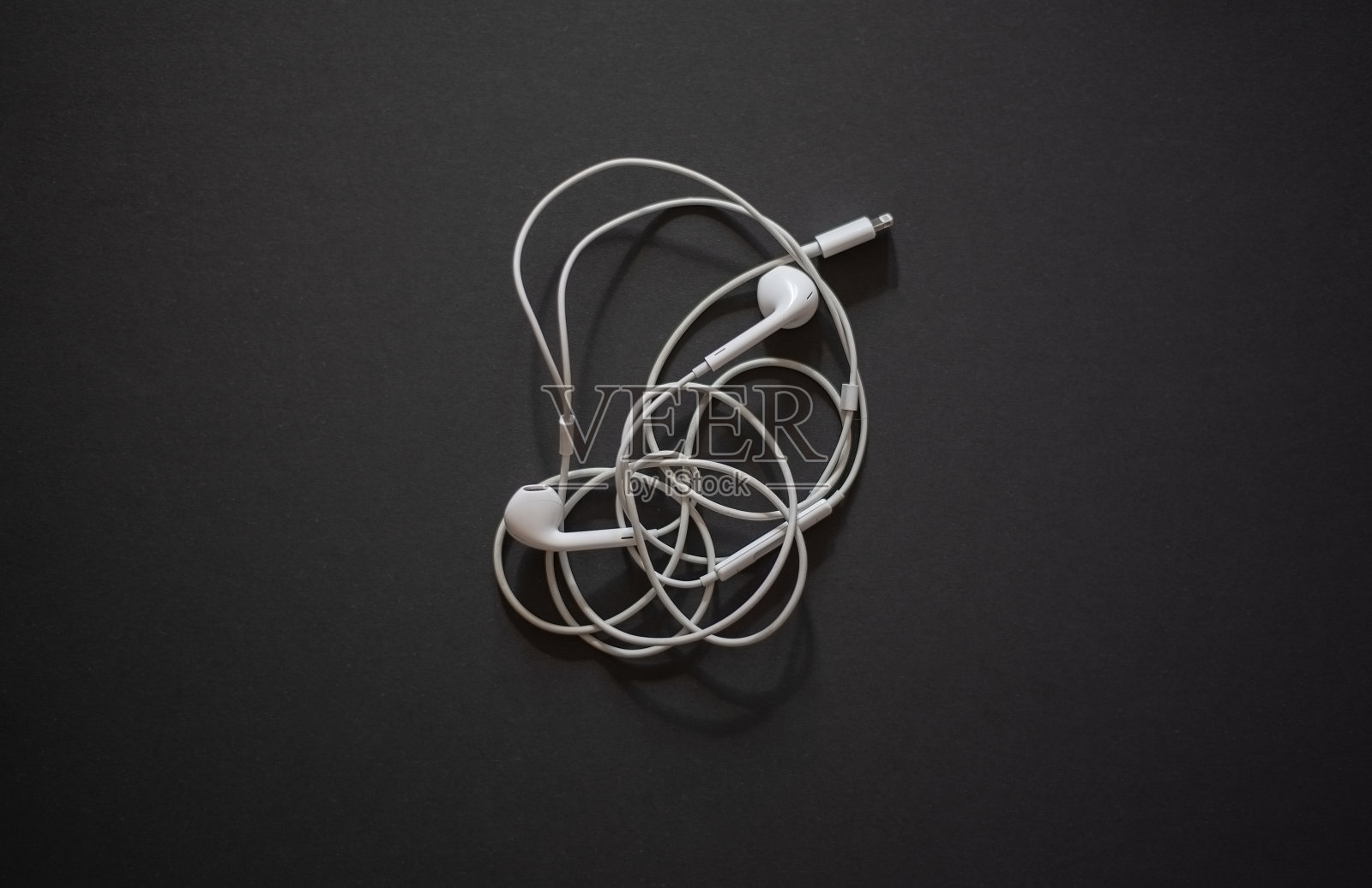有线耳机在黑暗的背景。照片摄影图片