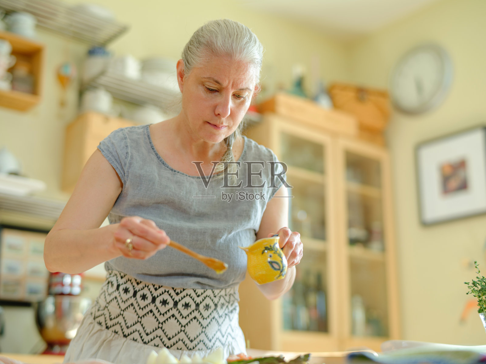 成熟的女人在准备尼斯沙拉照片摄影图片