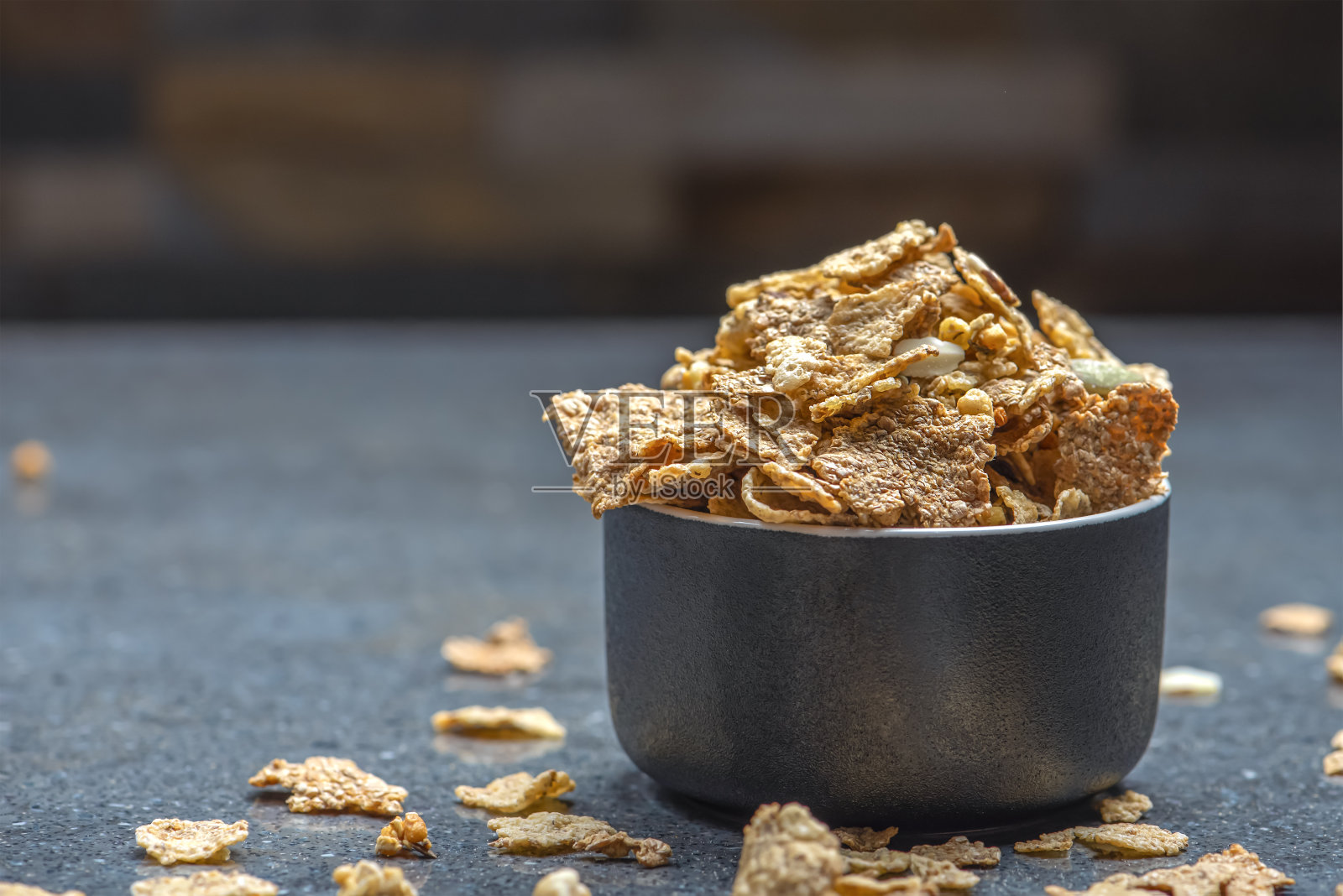 在石制桌面背景下的碟子里晾干麦片。健康食品和清淡饮食早餐概念，复制空间照片摄影图片