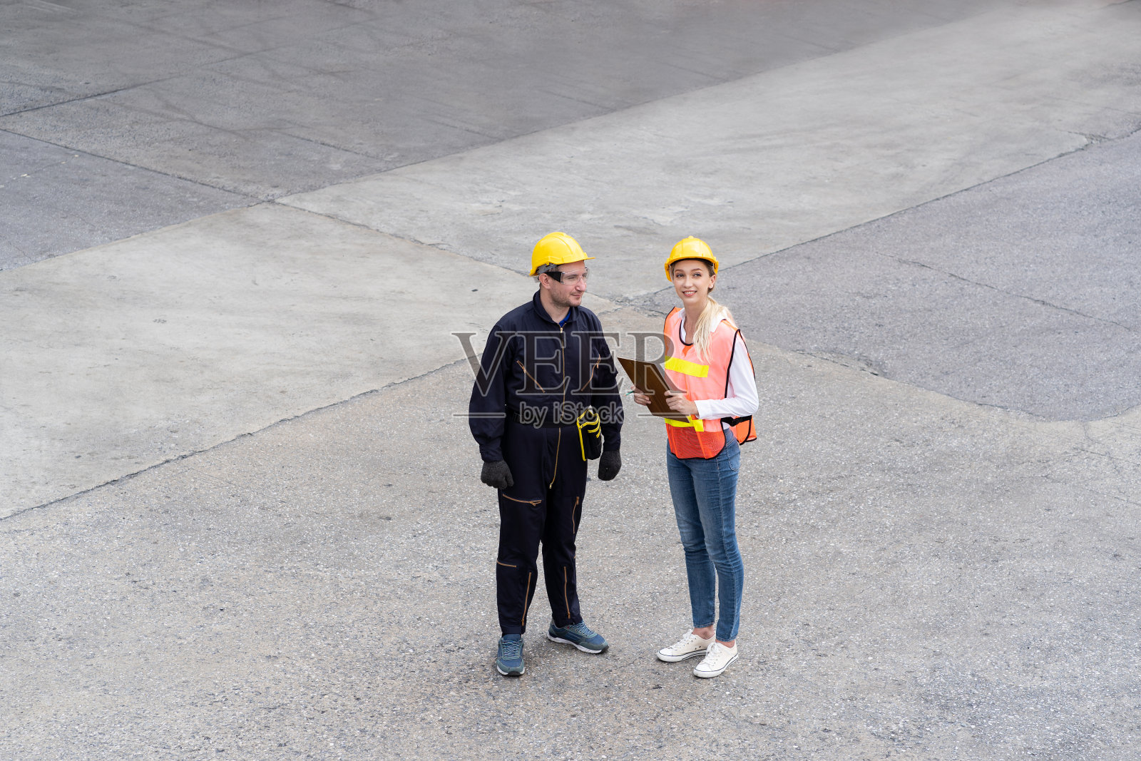 领班或主管穿着制服，头戴黄色安全帽，在控制货物货轮上的进出口集装箱装箱前，检查文件上的产品。货物照片摄影图片