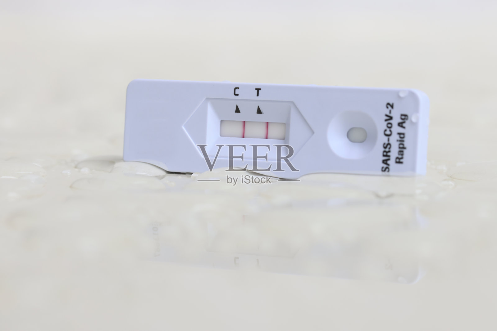 在水滴湿地板上的侧流home测试套件的特写。积极的照片摄影图片