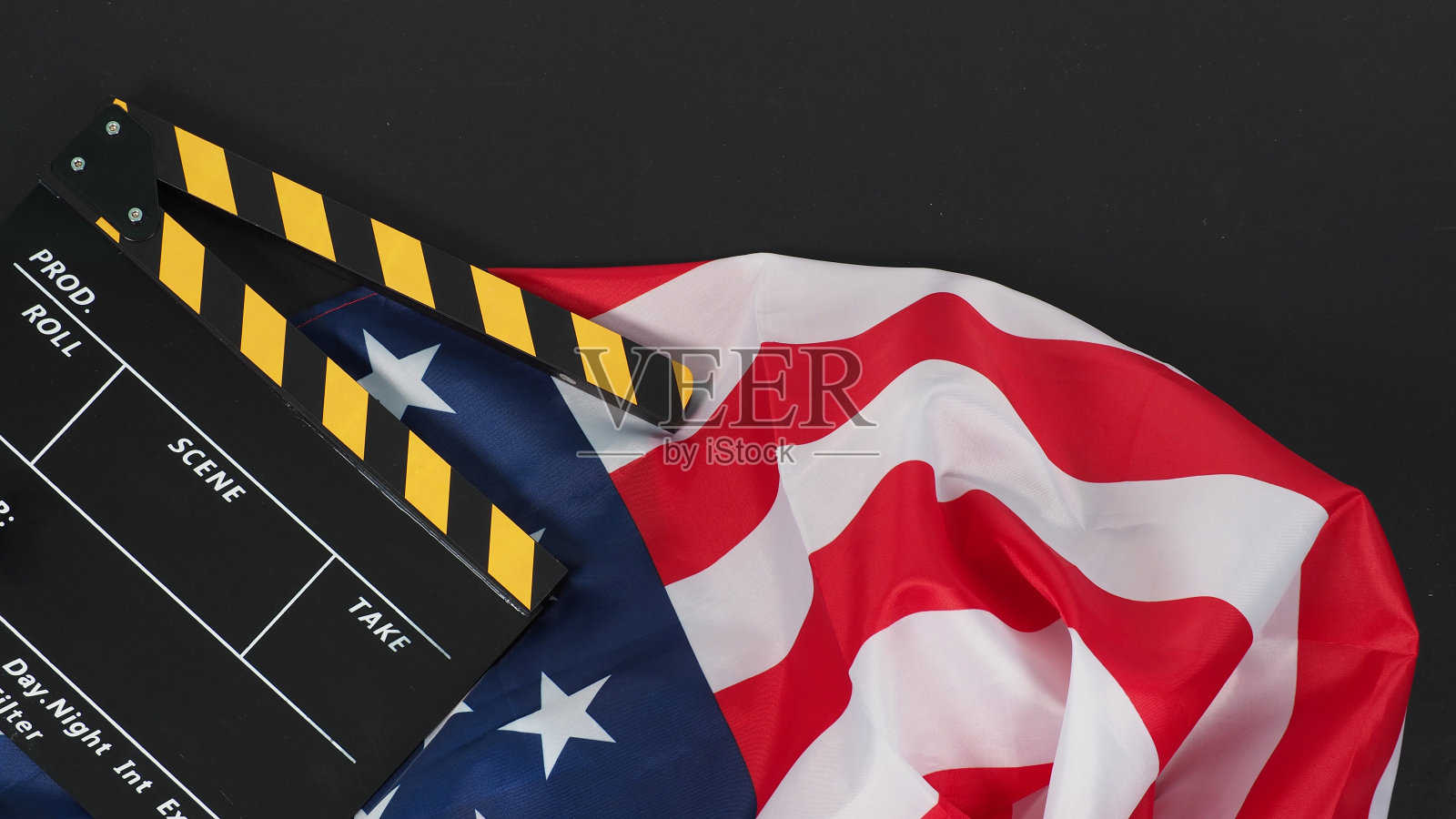 黑色和黄色的拍板或电影石板和美国国旗(美国)的黑色背景。照片摄影图片