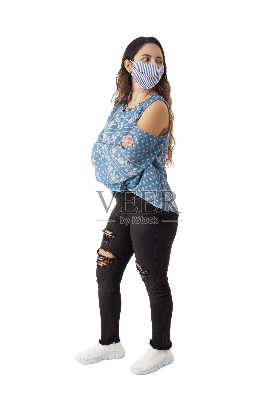 戴着口罩的年轻女子回头看照片摄影图片