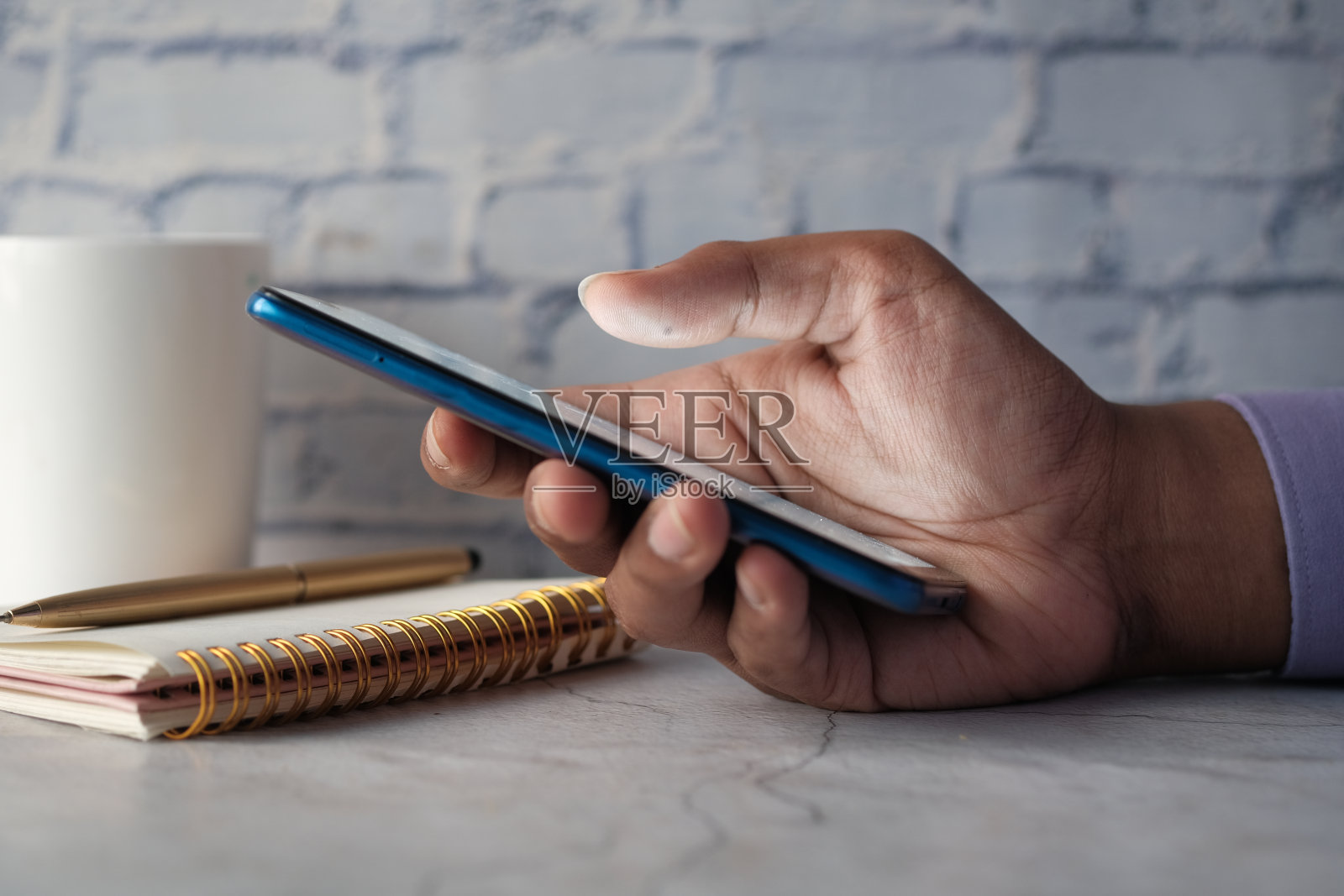 年轻男子的手在使用智能手机。照片摄影图片