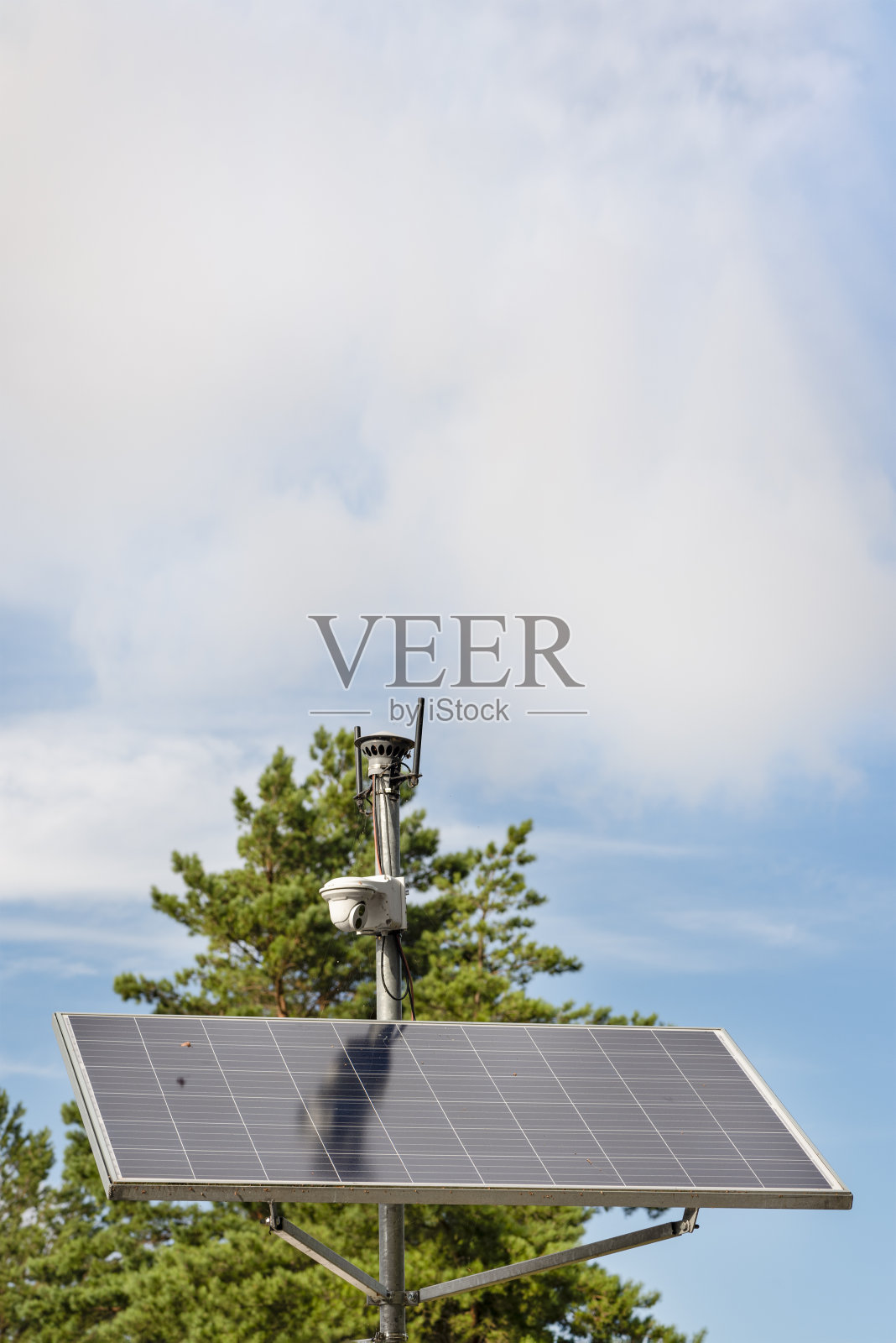太阳能监控摄像头。在蓝天的背景下，为城市公园的监控摄像头供电的太阳能电池板。安全清洁能源理念照片摄影图片