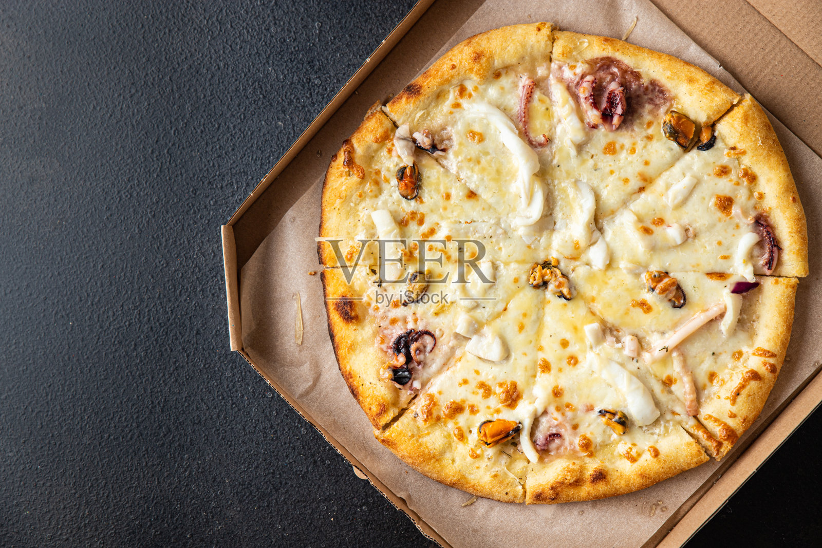 披萨海鲜贻贝、虾、章鱼、扇贝、芝士等新鲜的部分随时可吃的正餐小吃在餐桌上复制空间食品的背景质朴。俯视图照片摄影图片