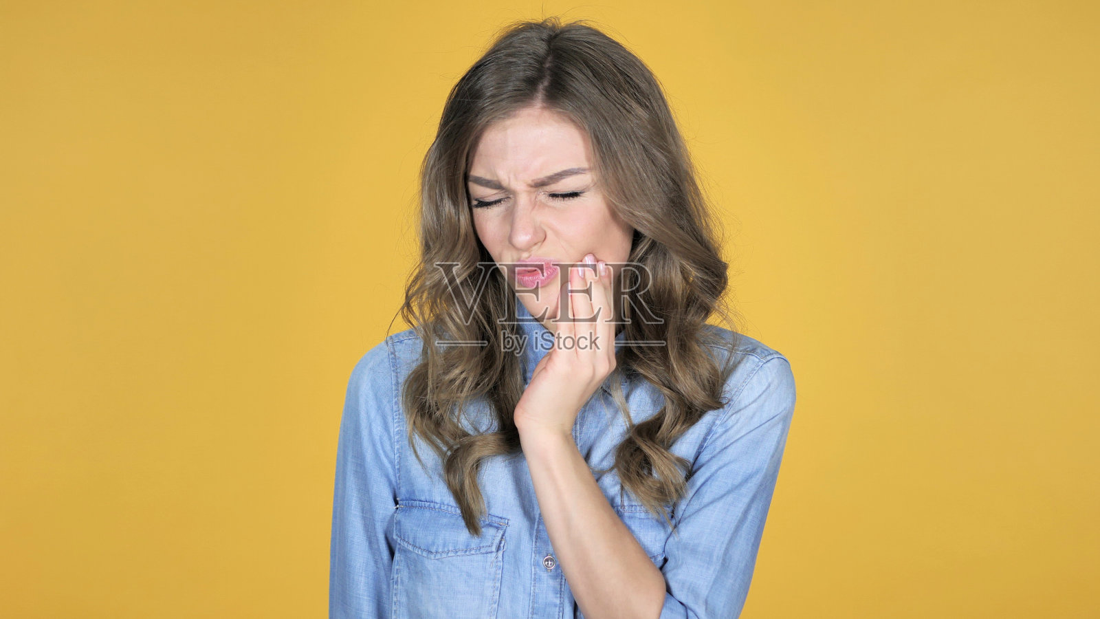 牙痛，小女孩与牙痛孤立在黄色背景照片摄影图片