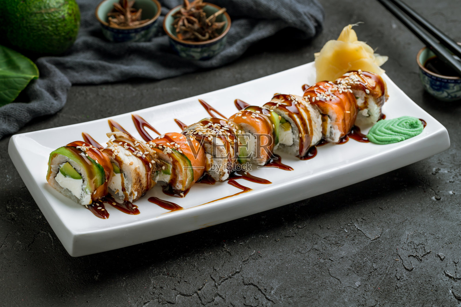 费城卷配鳗鱼、三文鱼和奶油芝士，放在深色的石桌上照片摄影图片