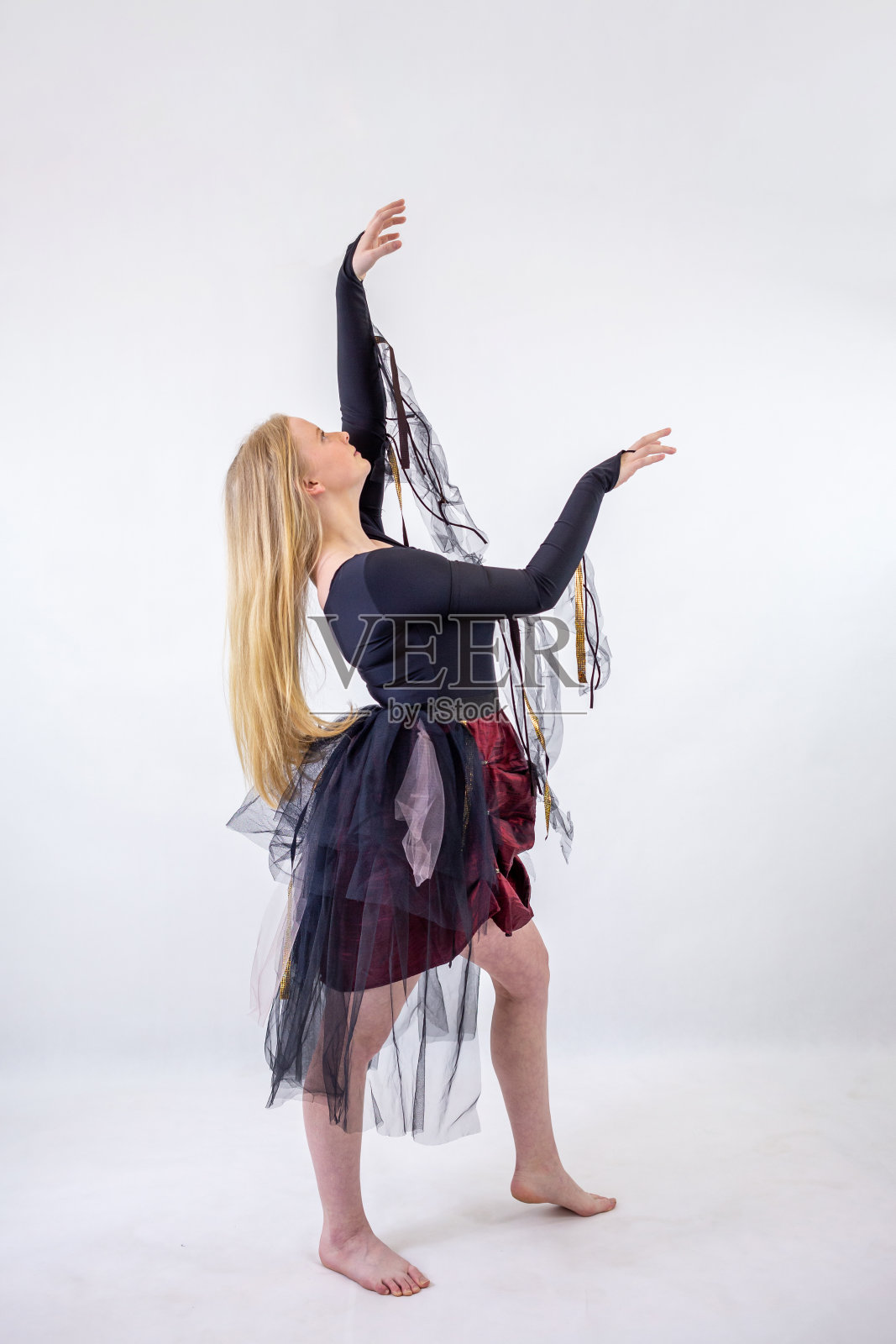 年轻的金发碧眼舞女在白色的背景上幻想的衣服照片摄影图片