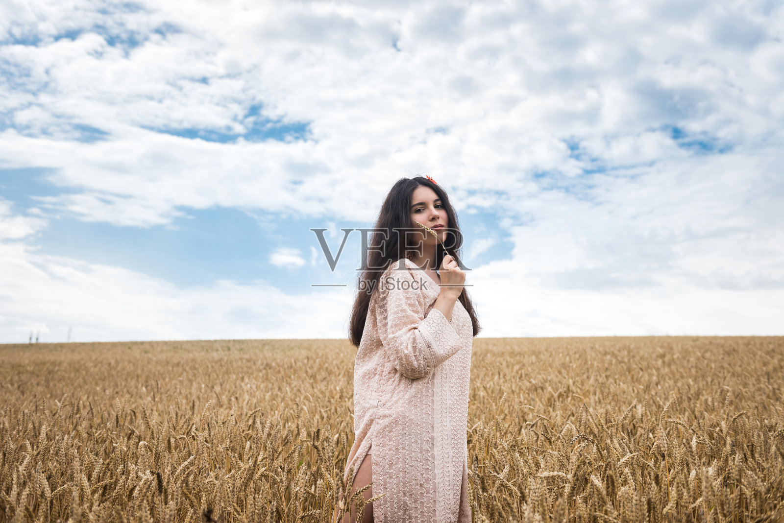 穿着夏装的年轻女子站在麦田里享受着生活照片摄影图片