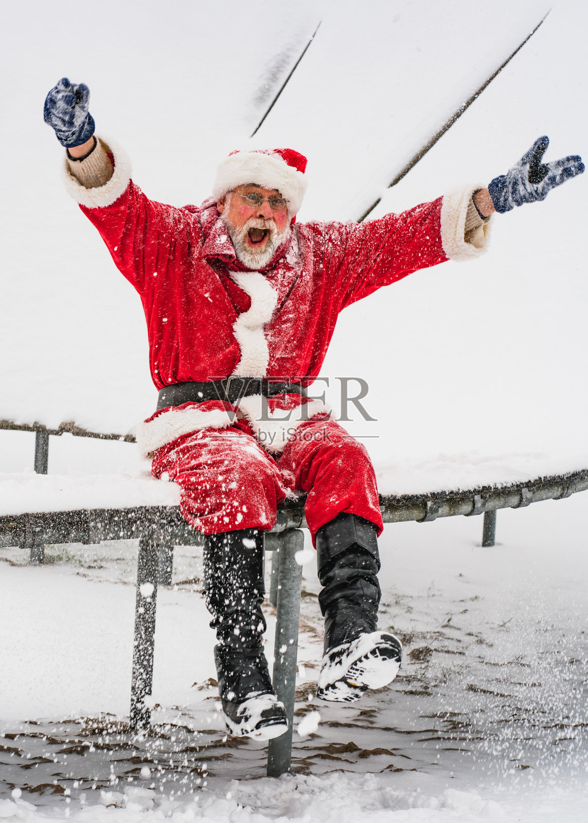 喜悦!热情的圣诞老人坐在那里，举起双手，热情地大喊。照片摄影图片