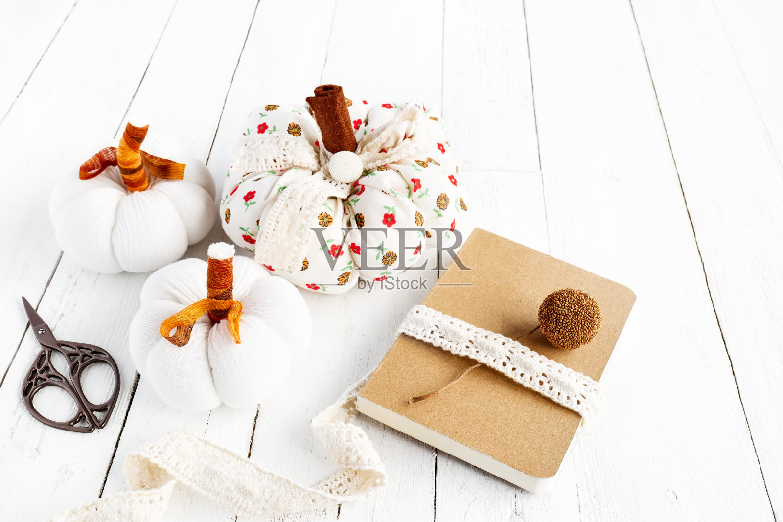 舒适的南瓜。秋天装饰与手工彩色织物南瓜和规划师或书在白色木制背景。共鸣。感恩节装饰。照片摄影图片