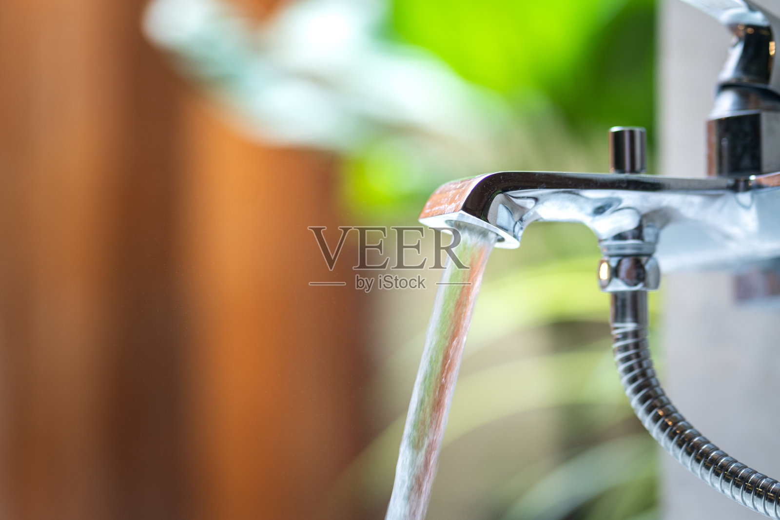 将清洁的水从水龙头注入浴缸。照片摄影图片