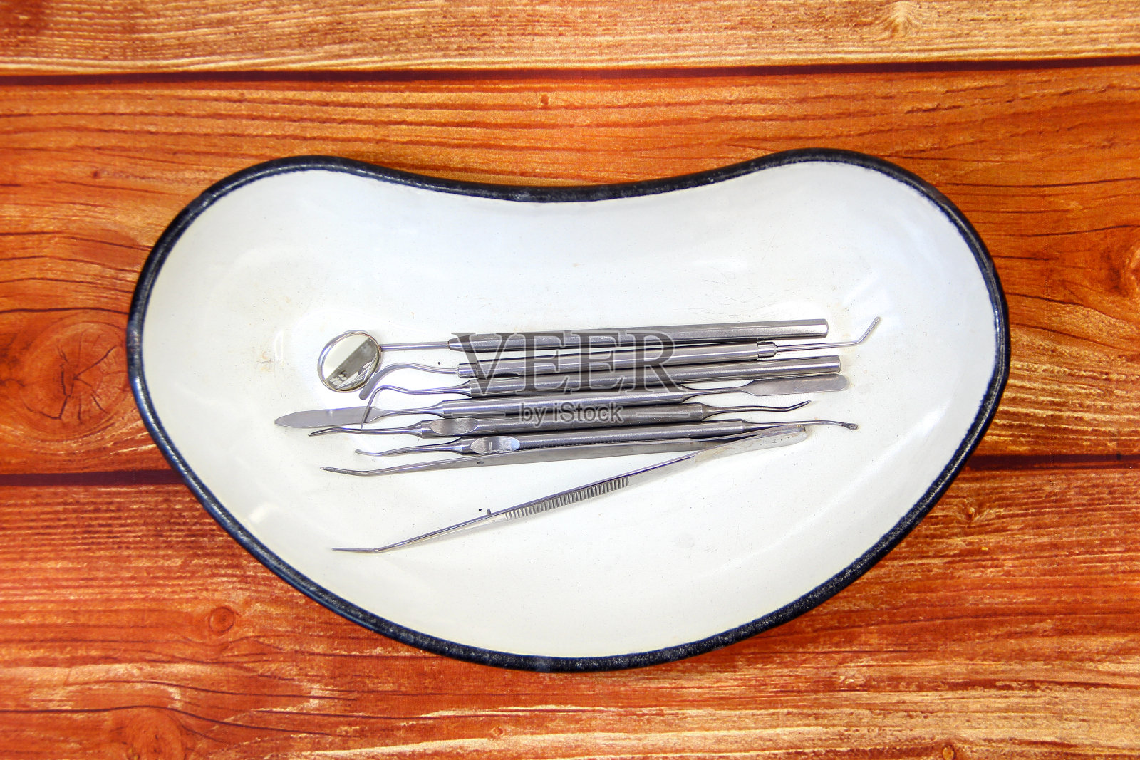 木制背景托盘内的牙科器械照片摄影图片
