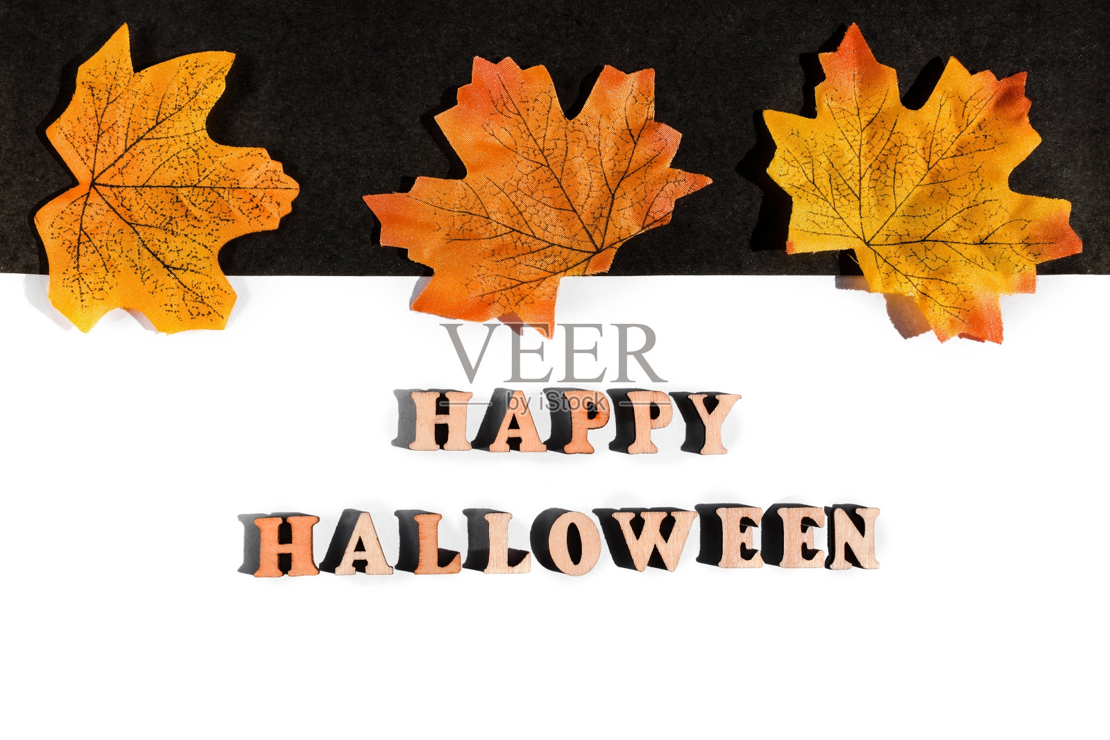 万圣节快乐。在黑白背景上。Copyspace。黄色的叶子排成一行照片摄影图片