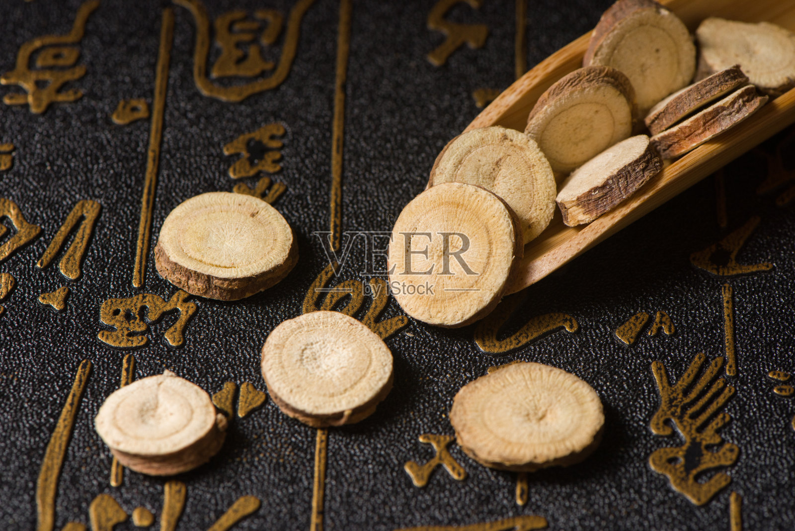 中草药，木制背景上的干甘草切片照片摄影图片