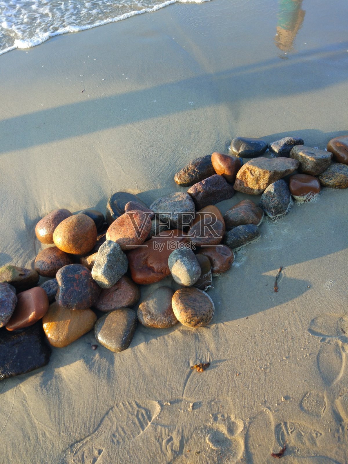 沙子上的小石头。照片摄影图片