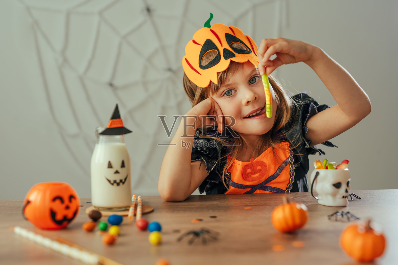 小女孩的肖像穿着万圣节女巫服装和南瓜面具照片摄影图片