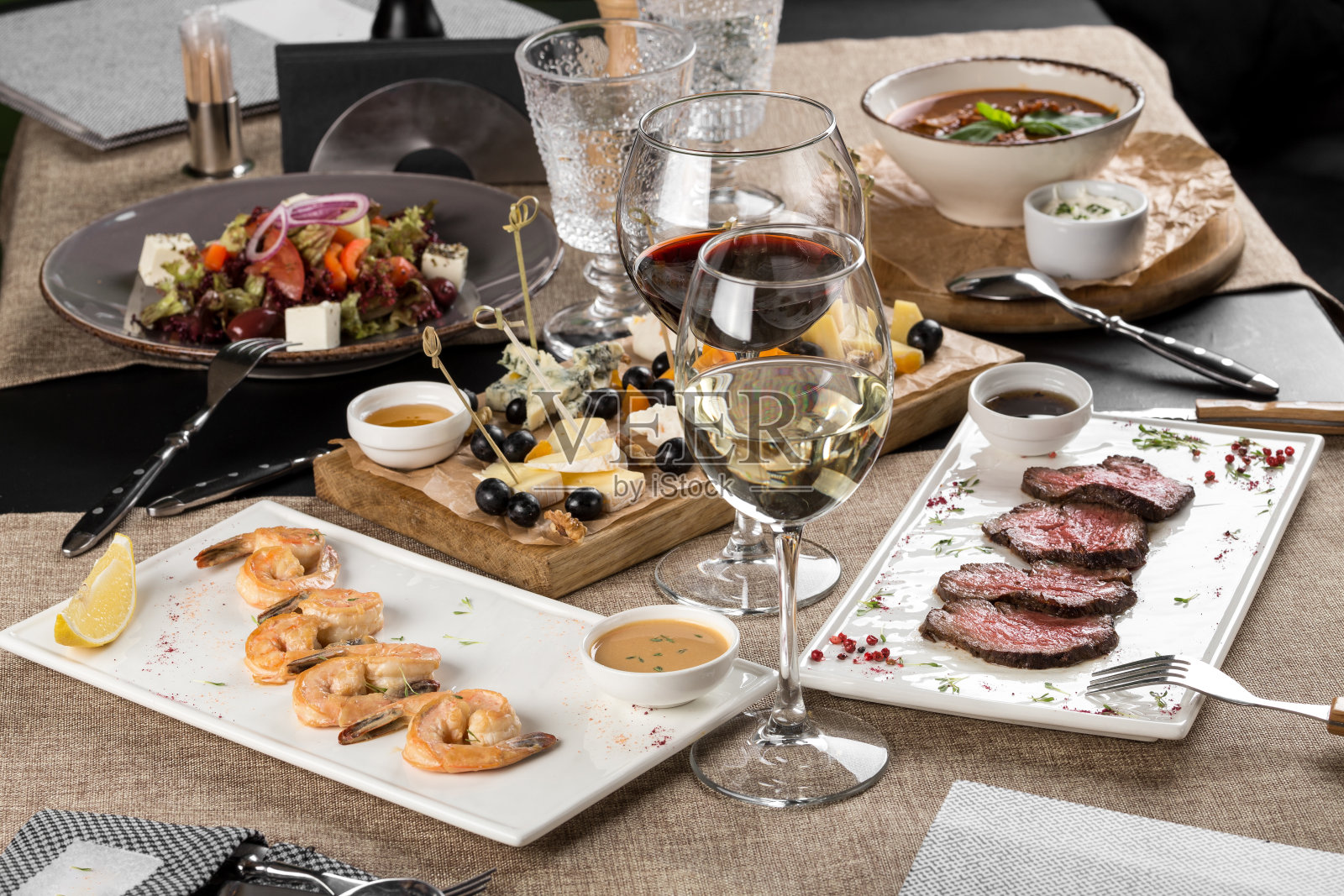 晚餐用虾，烤牛肉，沙拉，奶酪拼盘和葡萄酒在家或餐厅照片摄影图片