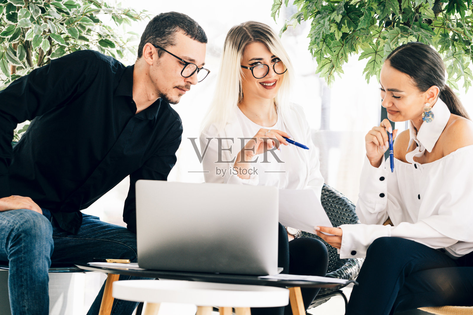 在办公室一起工作的年轻同事照片摄影图片