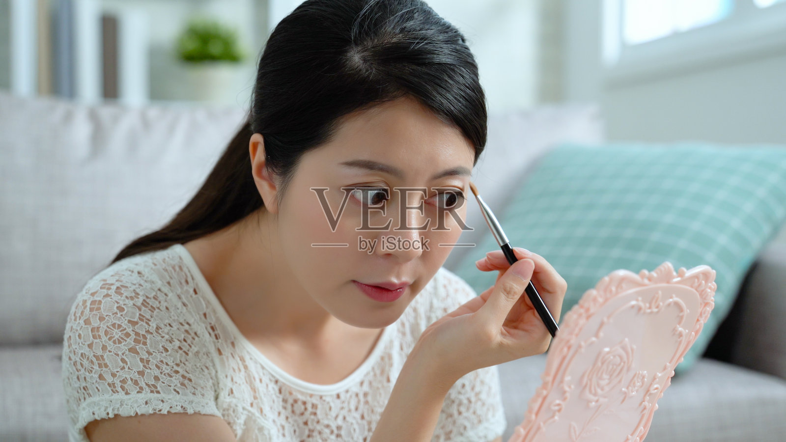 亚洲女人正对着镜子化妆照片摄影图片