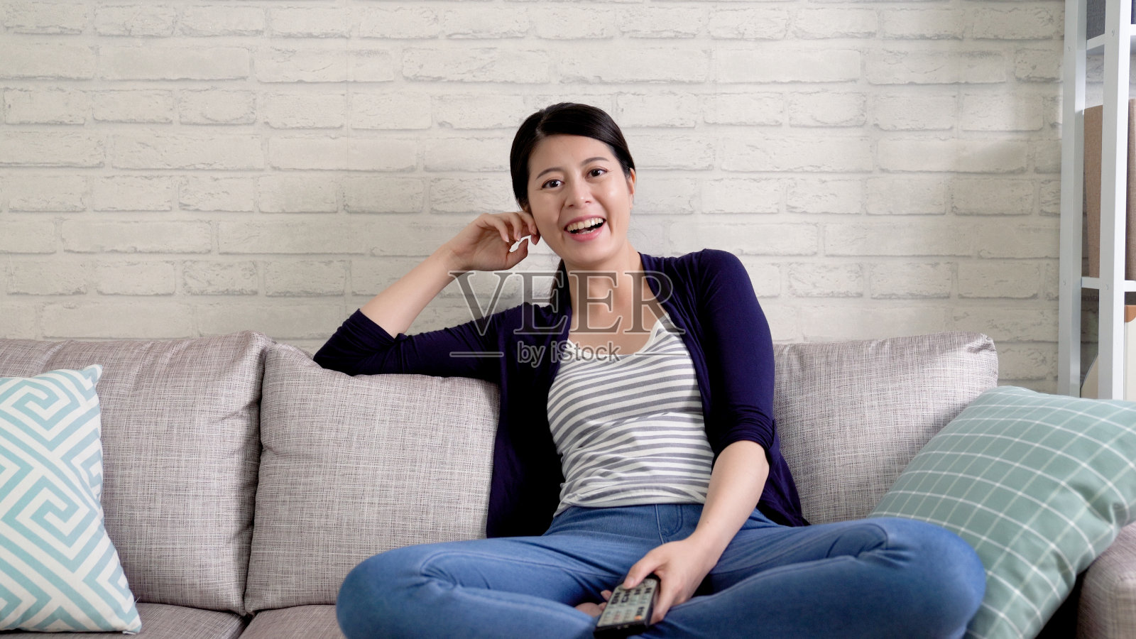 女孩拿着遥控器开心地笑着照片摄影图片