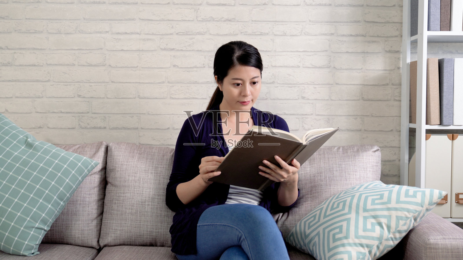 漂亮的大学生专注于课本照片摄影图片