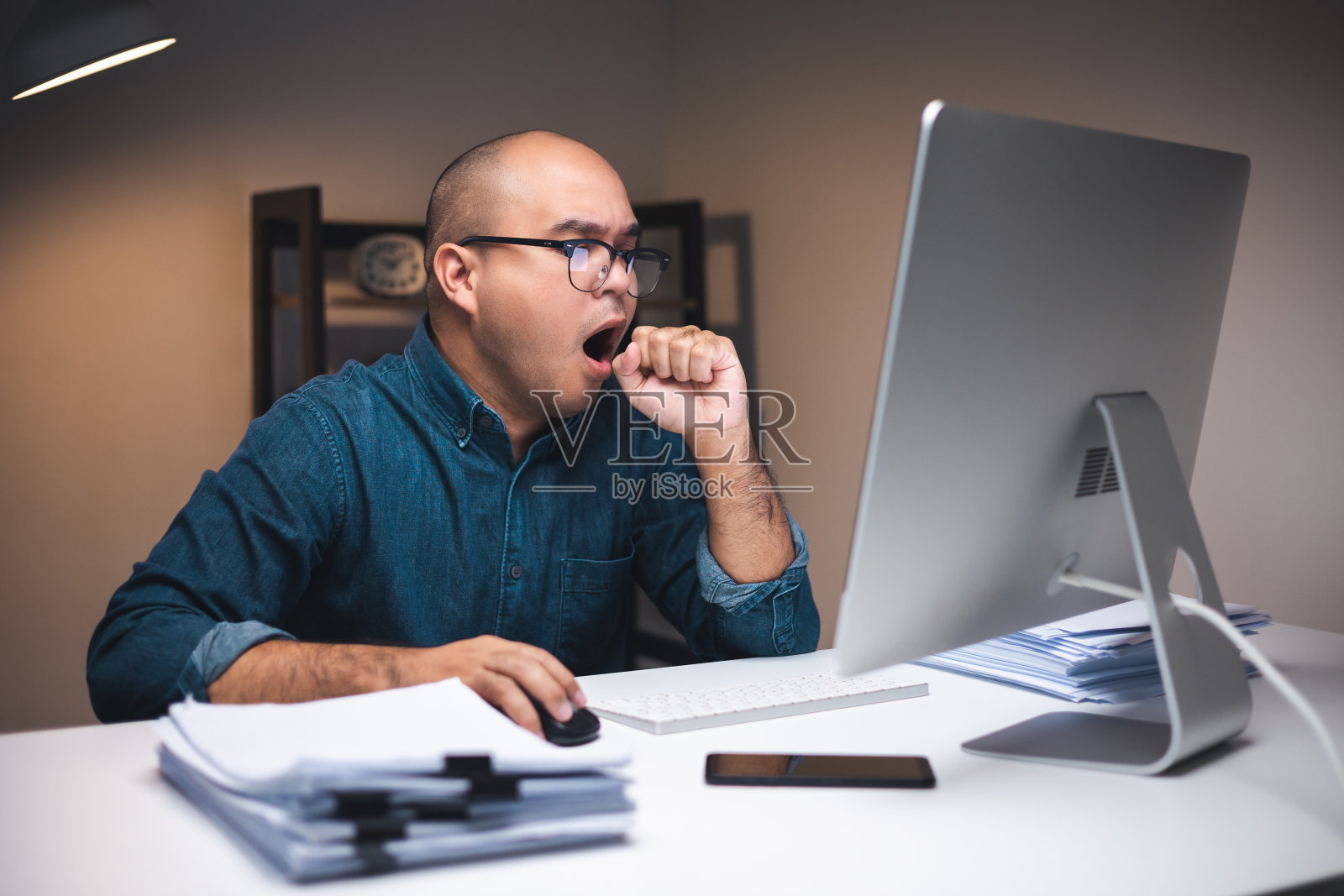 年轻自由职业者在光线昏暗的房间里熬夜用电脑工作照片摄影图片