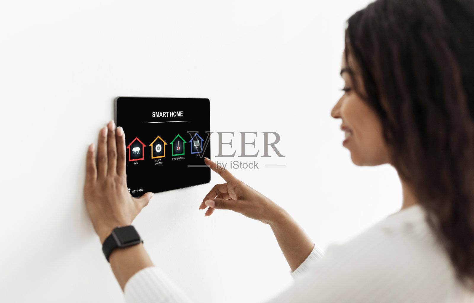 黑色女士使用智能家居设备，按下pad上的按钮照片摄影图片