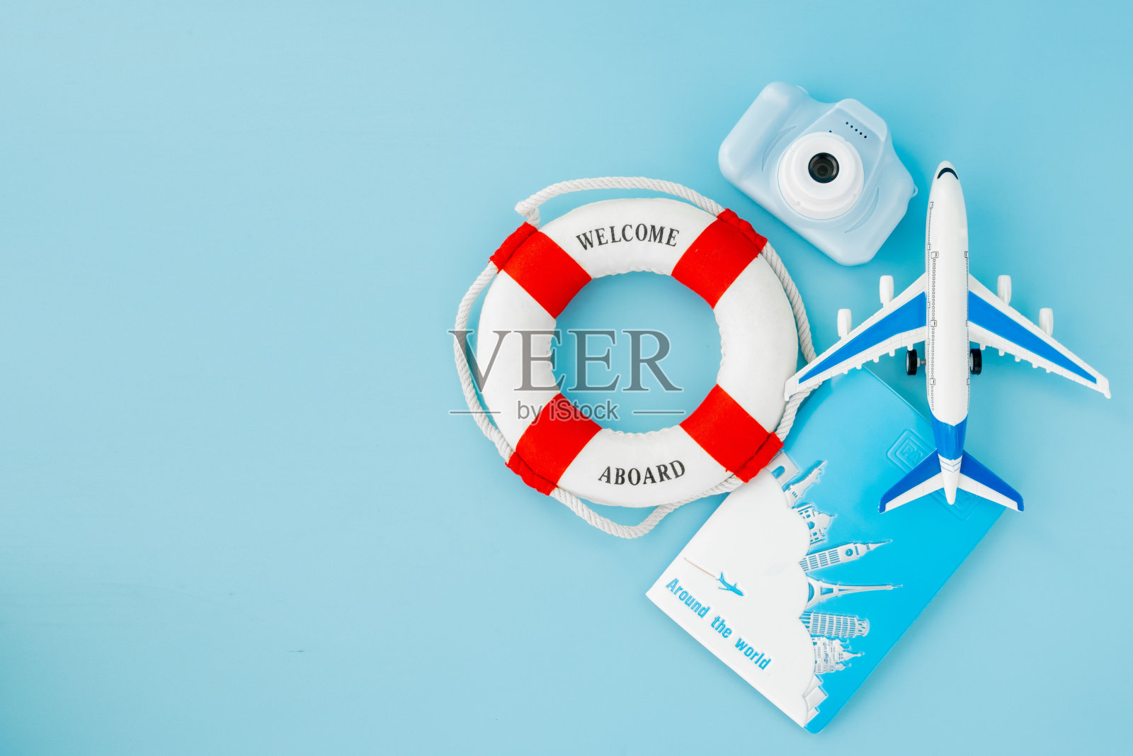 救生圈，护照，相机，飞机模型在蓝色背景上。夏季或假期的概念。本空间照片摄影图片